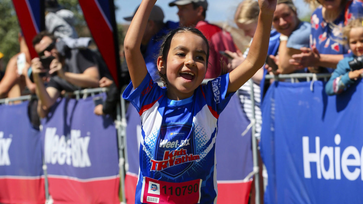 Child celebrating while running in a TRYathlon event.