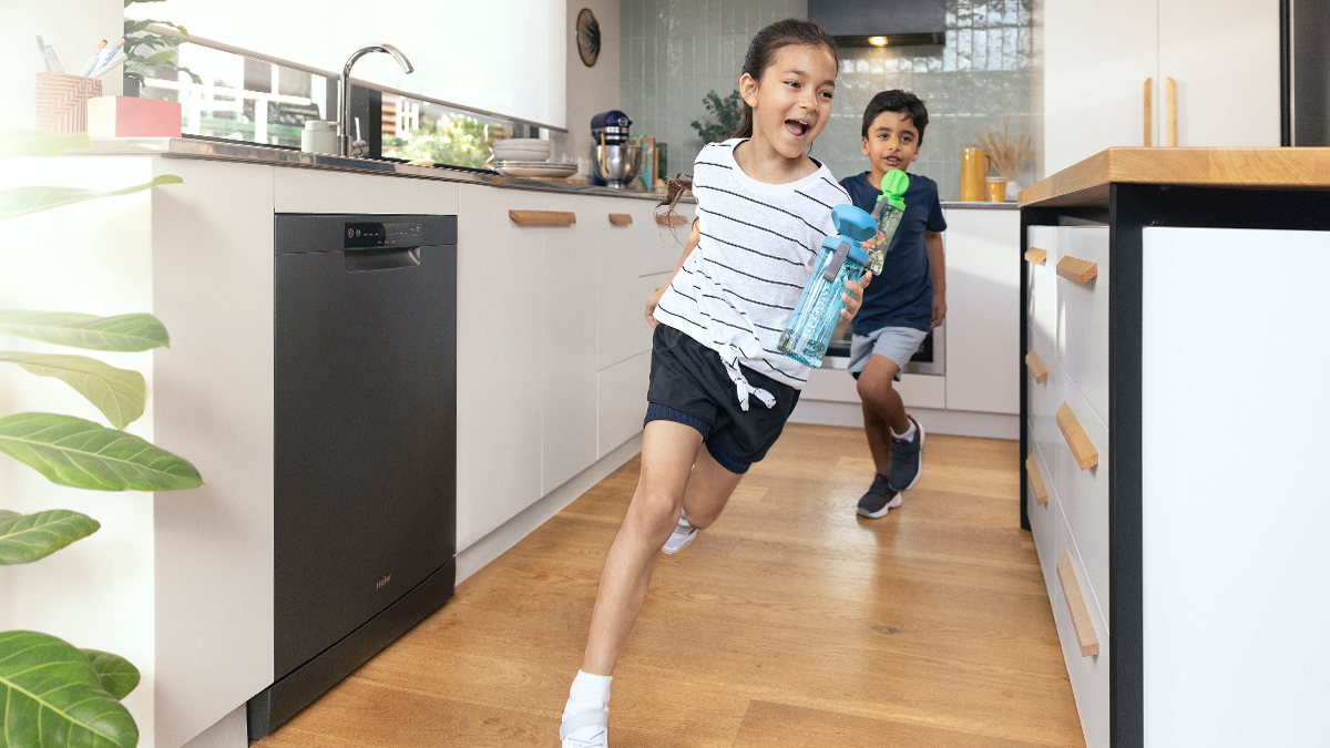 Girl and boy running through kitchen.