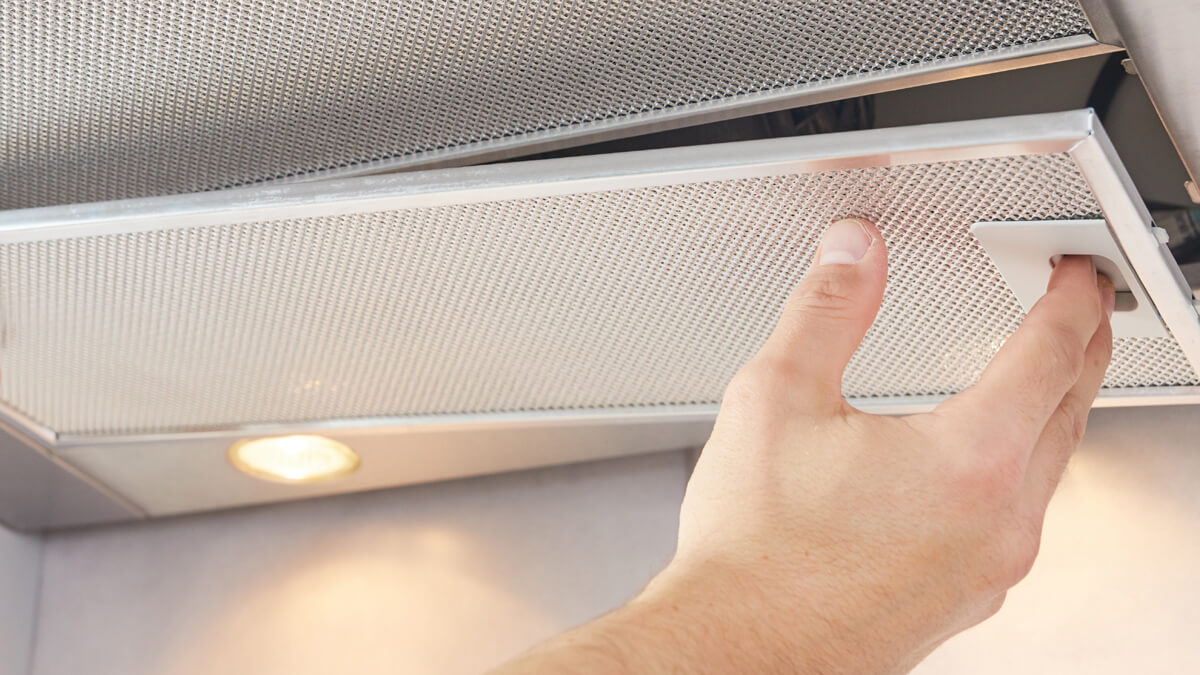 a close up of a rangehood filter being removed